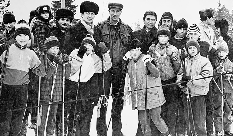 Юрий Кошкаров с первыйм тренером - Бонадревым Н.П. с юными лыжниками на соревнованиях Приз Олимпийцев.jpg